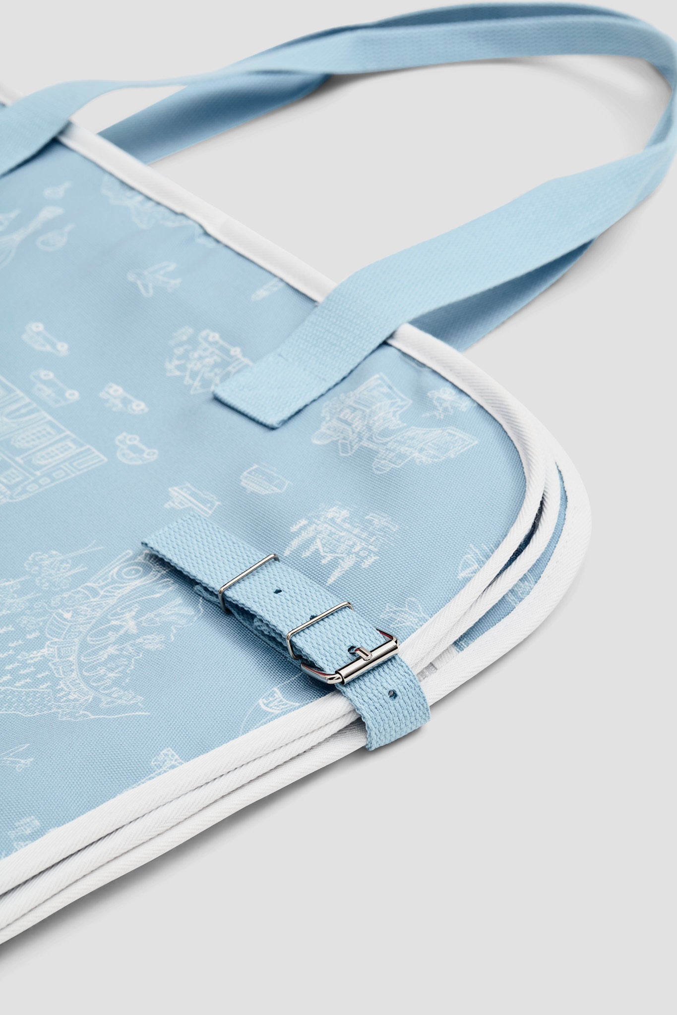 Detail image of garment bag folded with long straps for carrying and adjustable side straps with magnetic fastens.