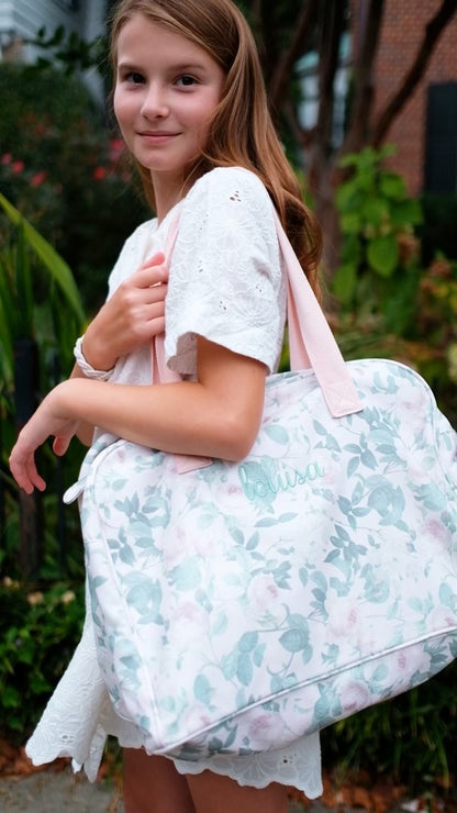 Tween girl holding floral duffle