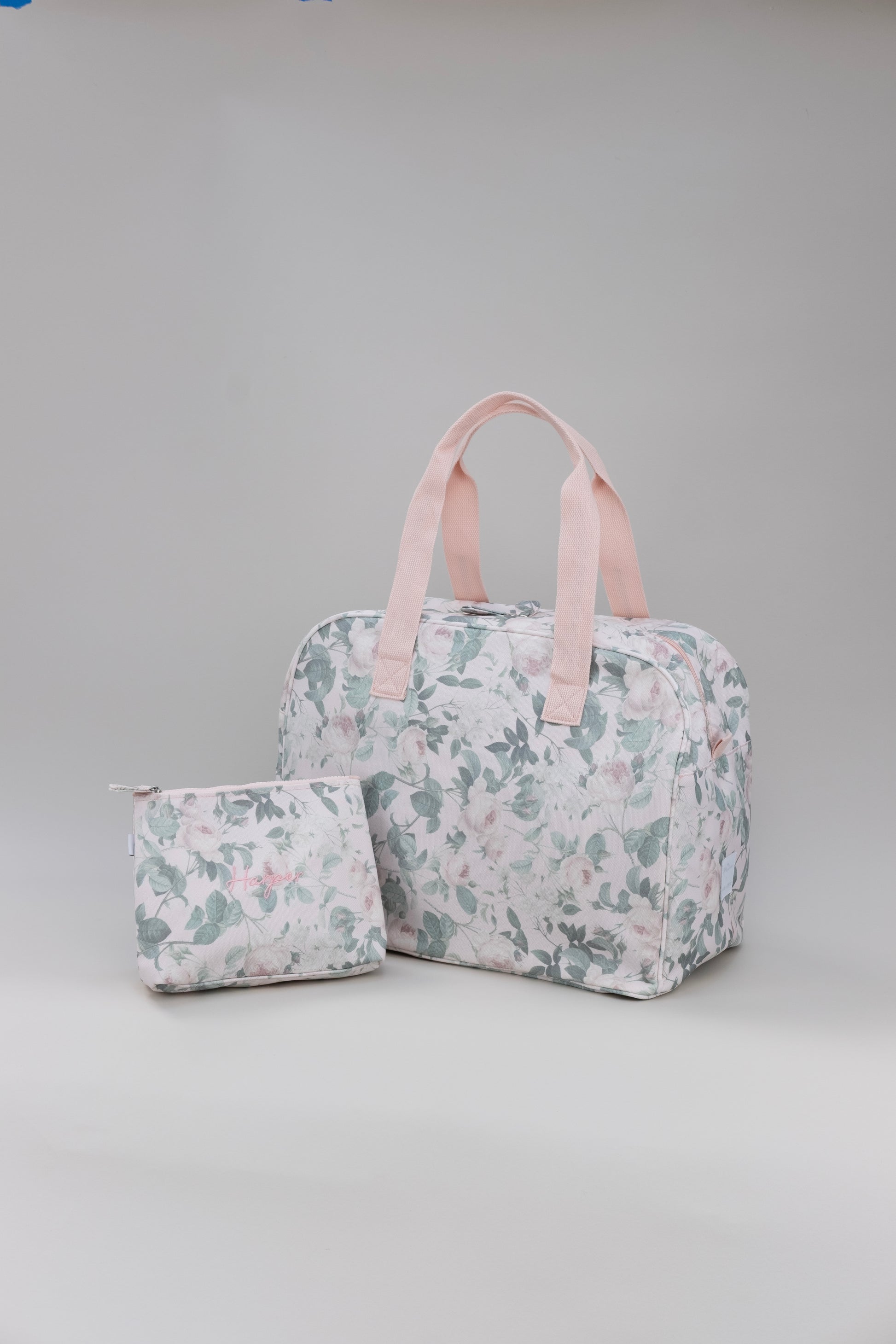 Floral-patterned toiletry bag and small pouch on a gray background