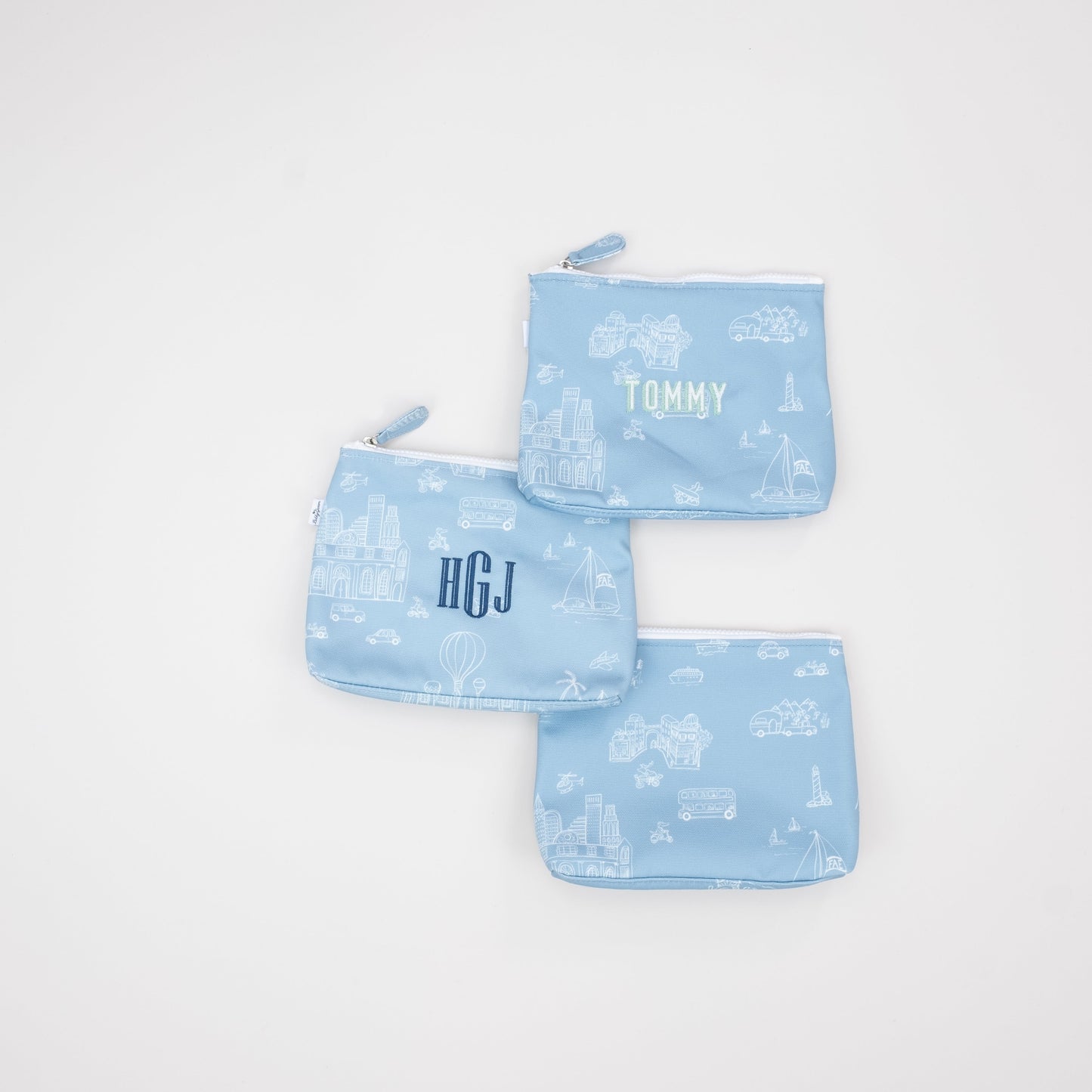 Three blue pouches with monogram examples Name, Initials or Plain on a light gray background