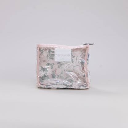 Clear plastic toiletry bag with a floral pattern on a light gray background