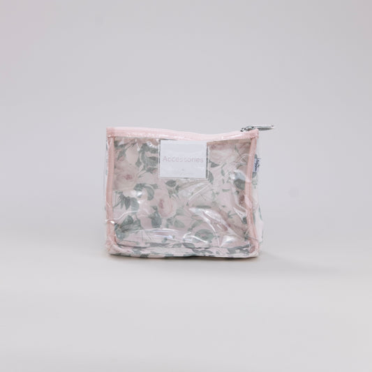 Clear plastic toiletry bag with a floral pattern on a light gray background