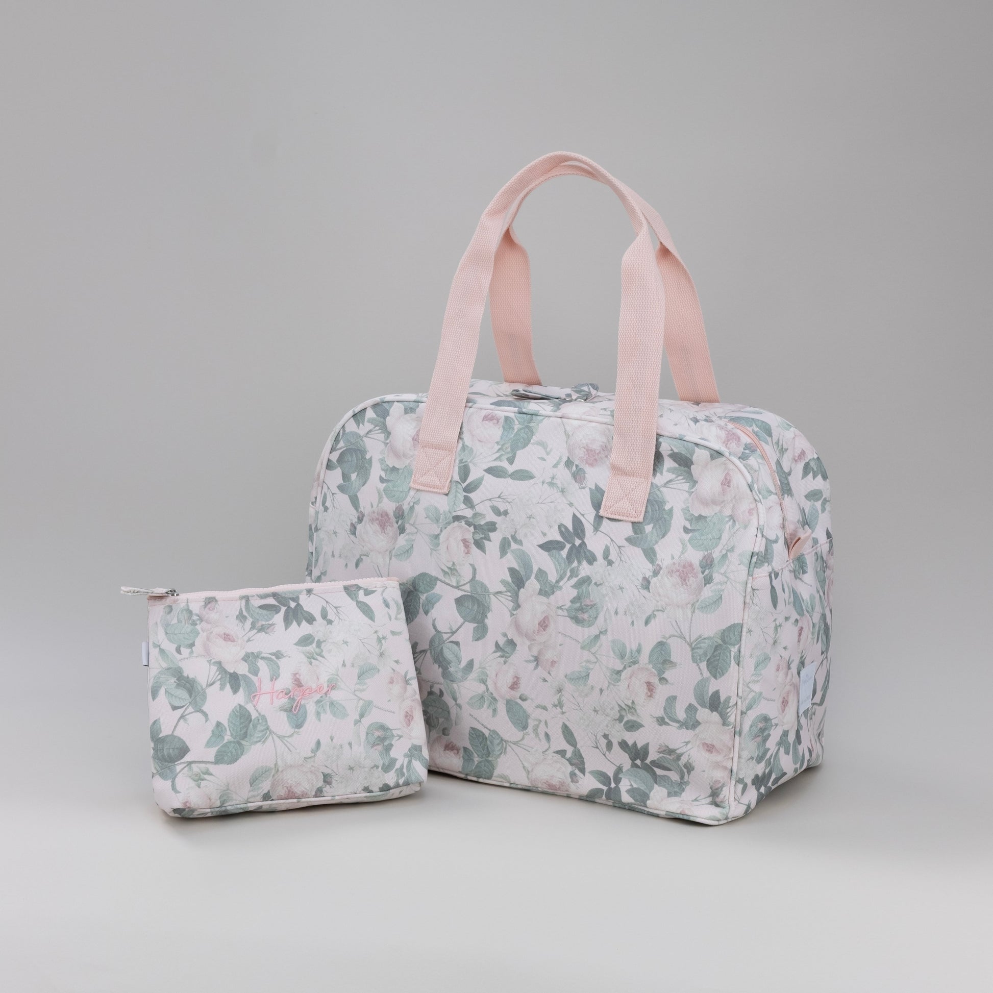 Floral-patterned duffle bag and small pouch on a gray background